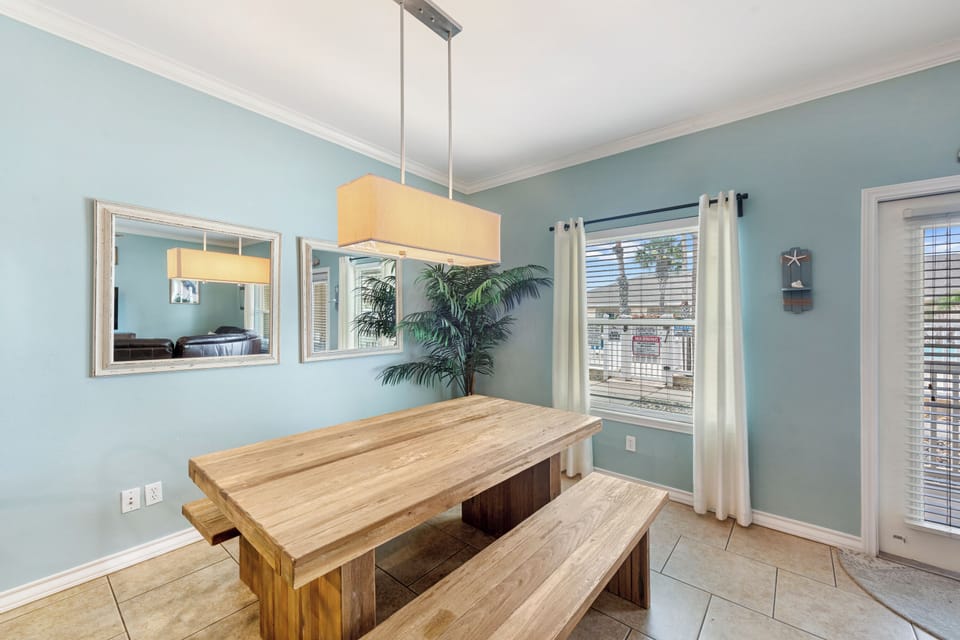 Gather around this beautiful wooden dining table where shared meals become cherished memories in your tranquil blue retreat.
