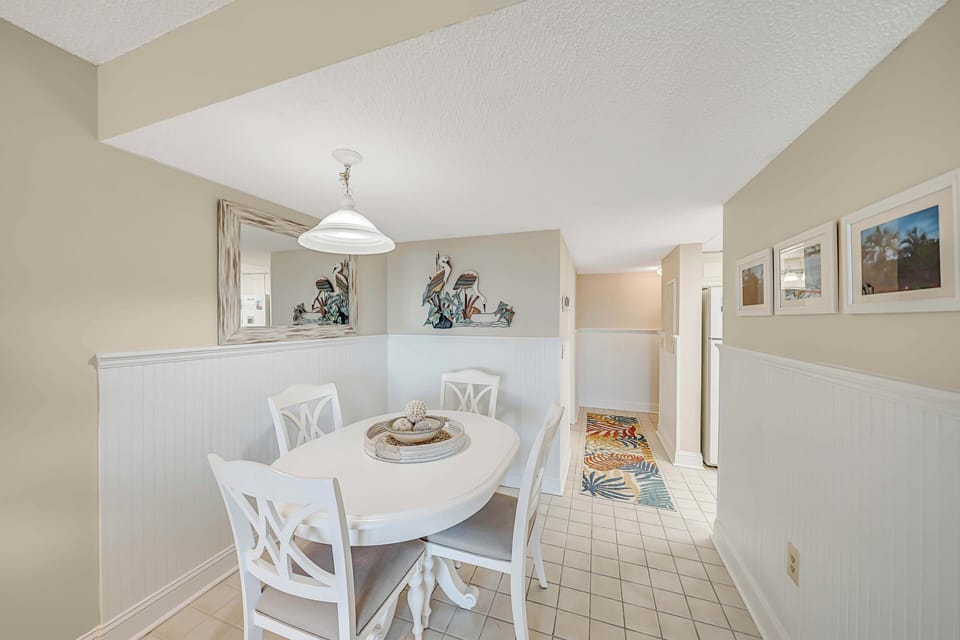 There is a dining table, perfect for enjoying a meal or playing a game, as well as additional breakfast bar seating.