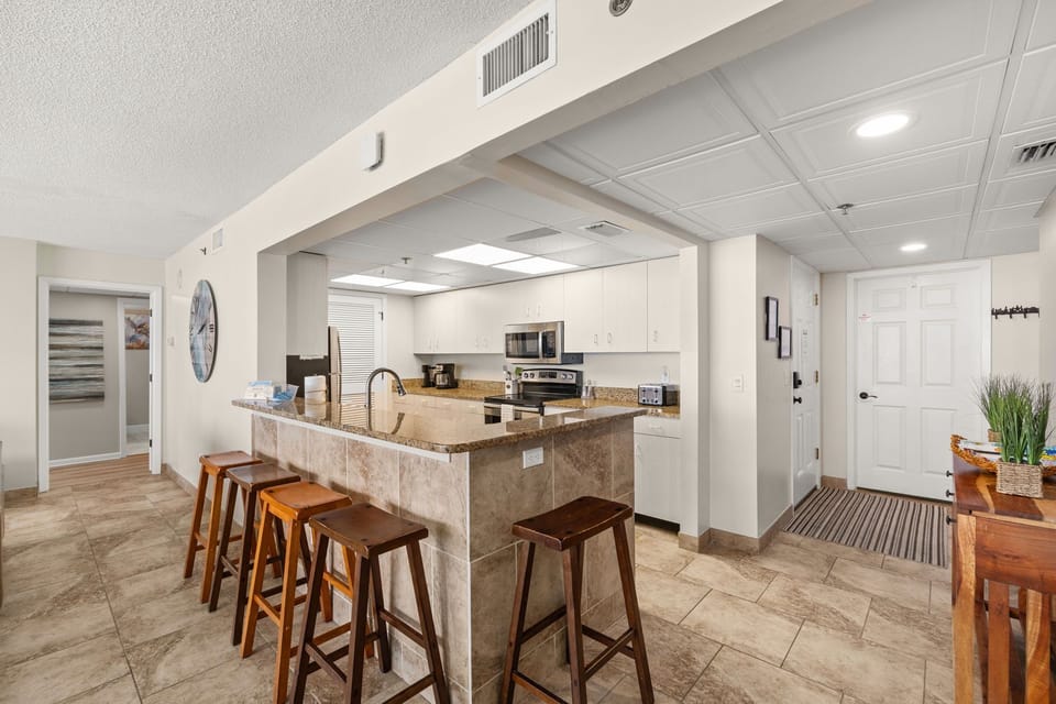 There is a dining table, perfect for enjoying a meal or playing a game, as well as additional breakfast bar seating.