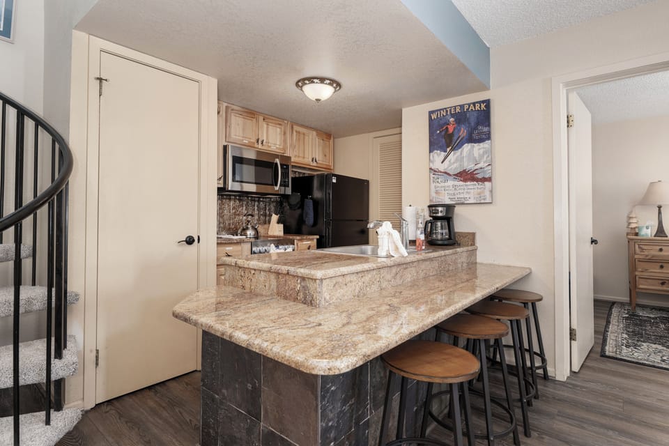 Your open kitchen at Summit Unit 1303 features granite countertops, modern appliances, and a convenient breakfast bar perfect for morning coffee or casual meals.