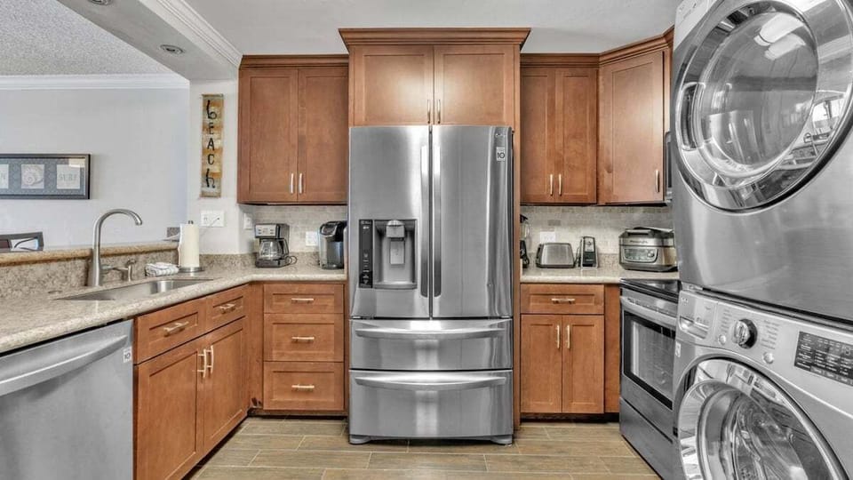 Kitchen with modern appliances, ample cabinets, and built-in washer and dryer—fully stocked for cooking and cleaning needs.