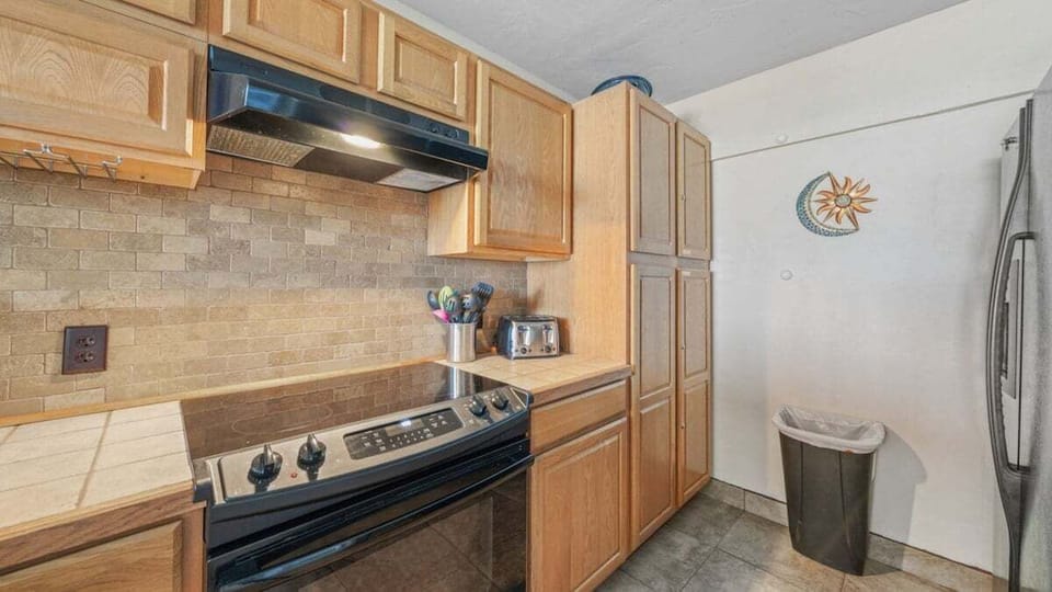 Spacious kitchen with plenty of cabinet storage, sleek appliances, and a warm tile backsplash.
