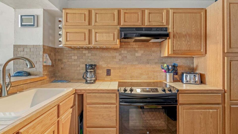 Fully equipped kitchen with wood cabinets, tile counters, and all the essentials
