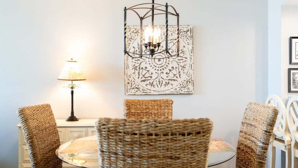 Charming Dining Nook – Gather around the glass-top table beneath warm lighting and coastal accents for memorable meals or morning coffee.