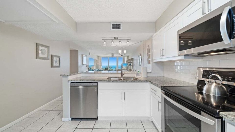 Modern kitchen with stainless appliances and granite counters.