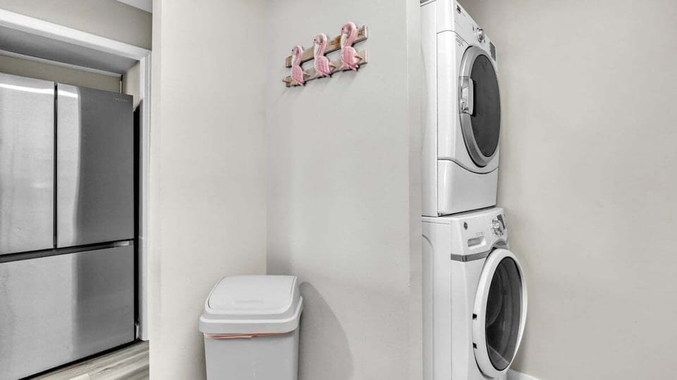 Unit includes in-home washer and dryer for easy beachwear refresh, plus a playful flamingo wall hook adding coastal charm.