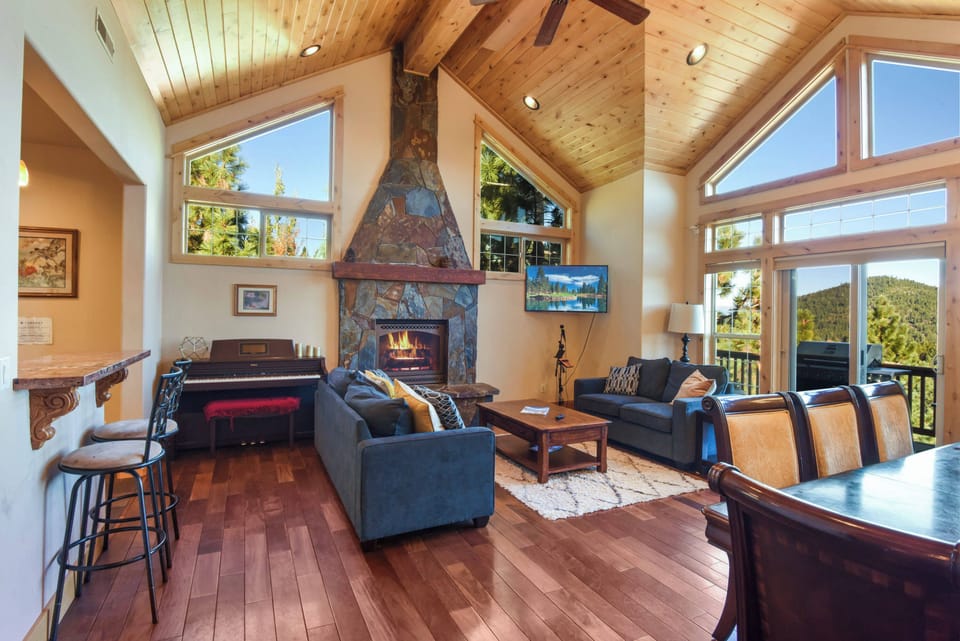 Living room with Smart TV, gas fireplace, piano and access to balcony