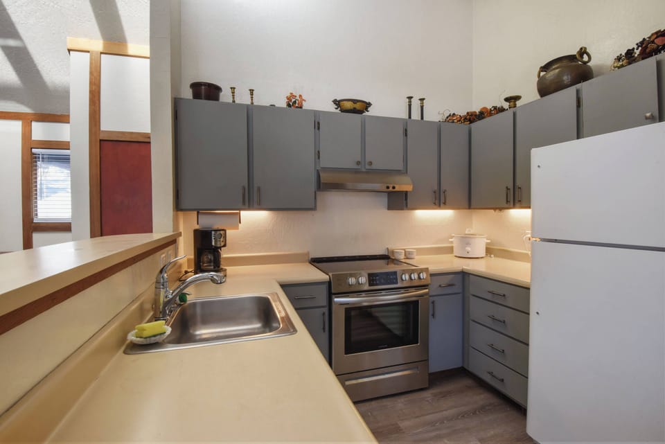 Kitchen with drip coffee pot, dishwasher, slow cooker and electric stovetop