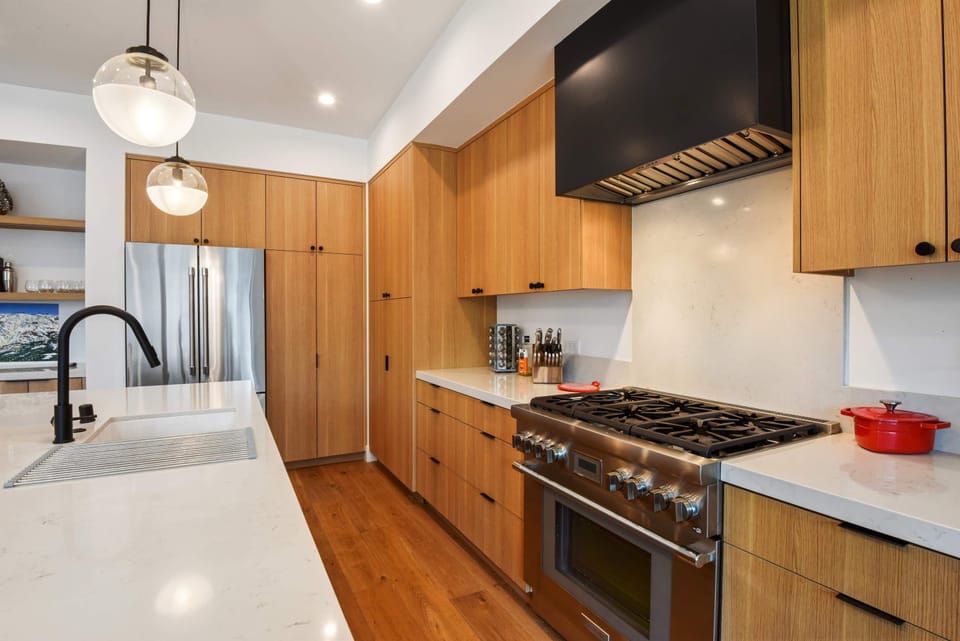 Modern kitchen with Nespresso, toaster, rice cooker, kettle, blender, wine fridge, and more