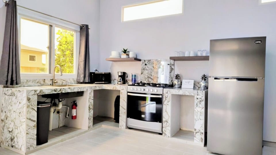 stovetop, refrigerator, oven, coffee and or coffee maker, microwave, kitchen.