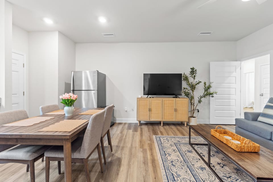 Relax in your bright open-plan space featuring a full kitchen, dining table for meals, and living area with TV for entertainment.