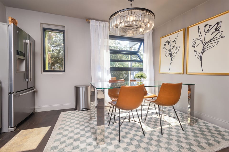 Open dining area with seating for four, featuring a beautiful chandelier.