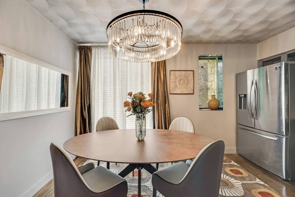 Open dining area with seating for four, featuring a beautiful chandelier..
