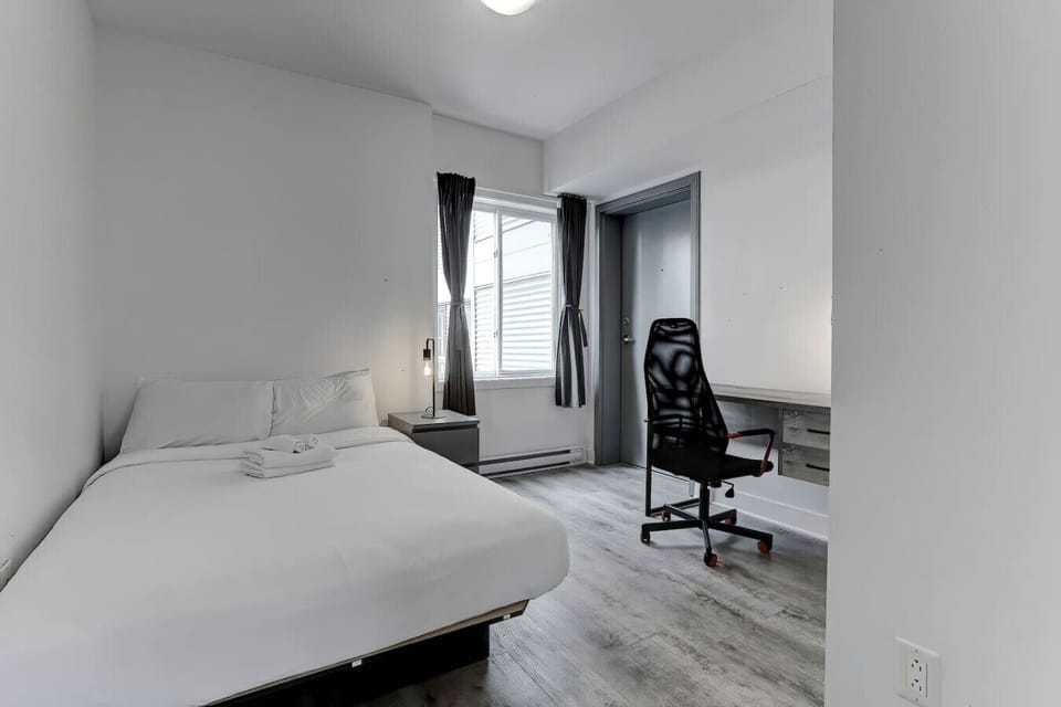 Bedroom 3 – A peaceful retreat with a large bed, work desk, and bright windows for a relaxing stay.