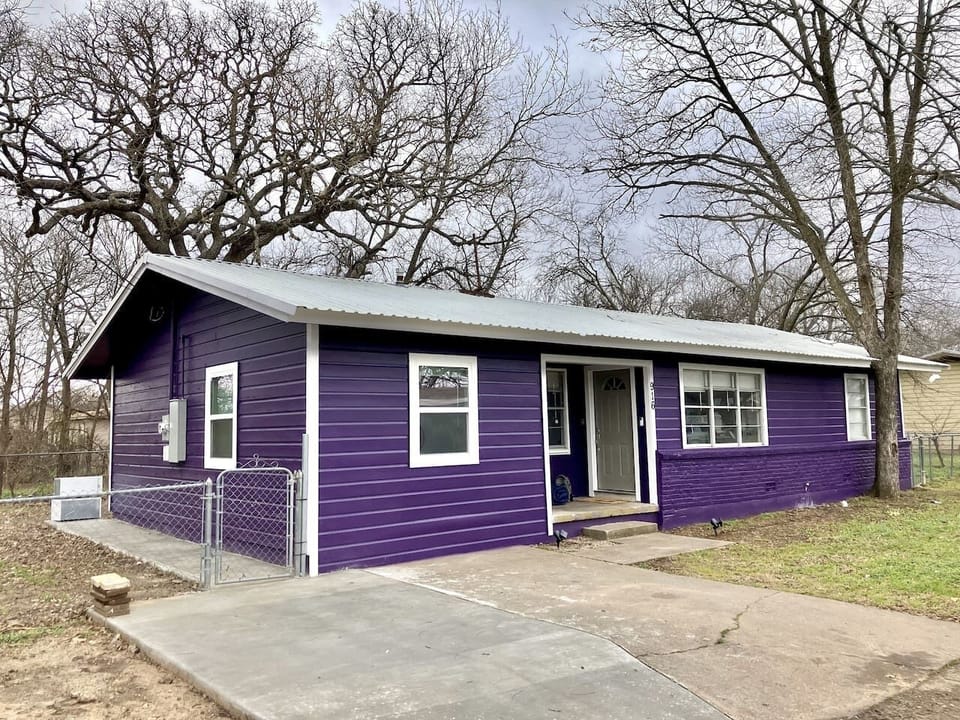 Charming exterior of The Purple House in Stephenville, just 1.2 miles from Tarleton State University, offering the perfect blend of style and convenience