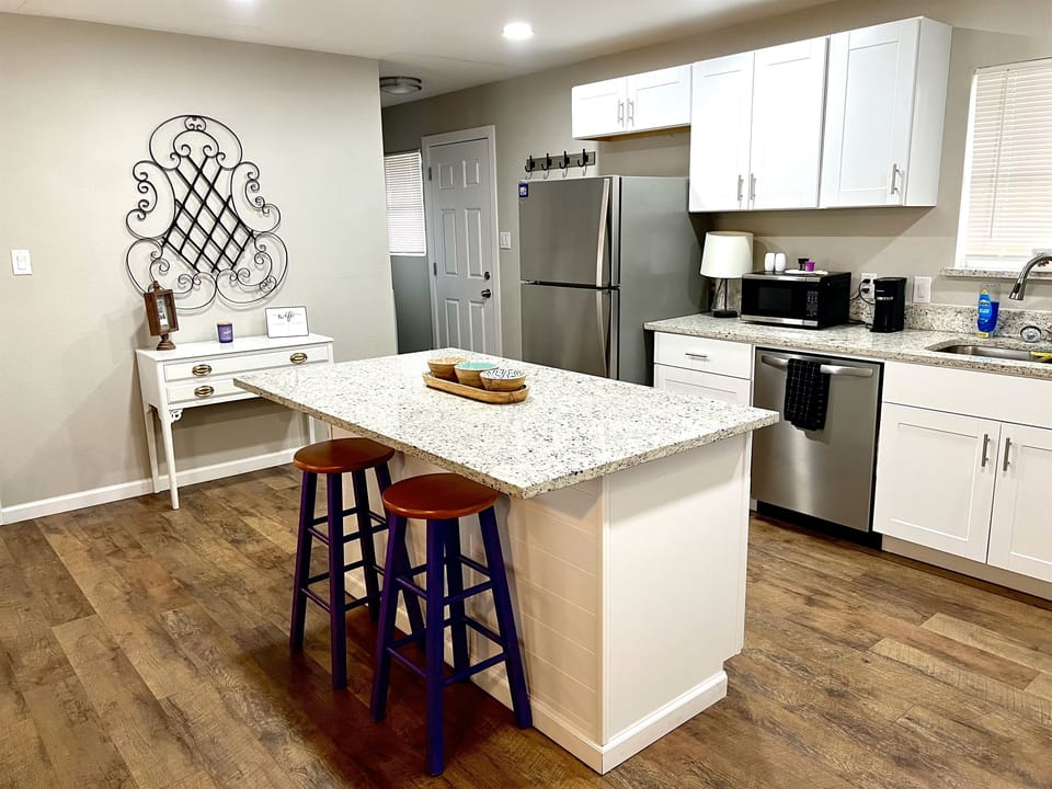 Fully stocked kitchen with modern appliances, granite countertops, and a large island, perfect for preparing meals