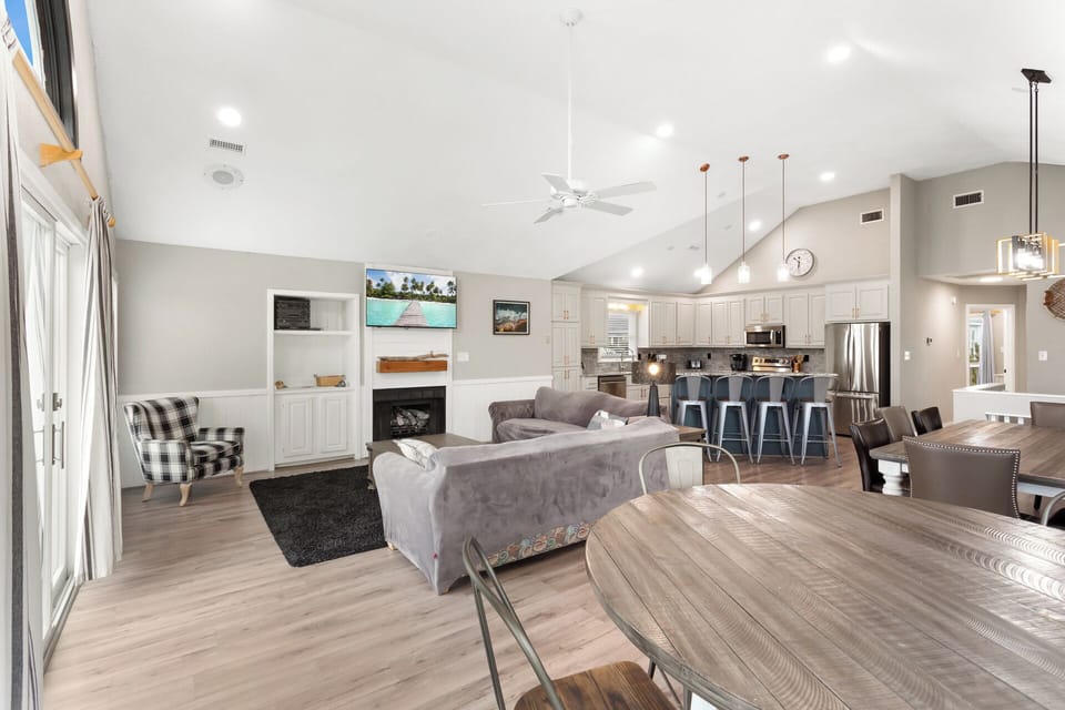 The Top Level of the home features an Open-Concept Living Area with comfortable furnishings, a Flat-Screen TV, and direct access to the Furnished Sun Deck, perfect for soaking up the coastal breeze.