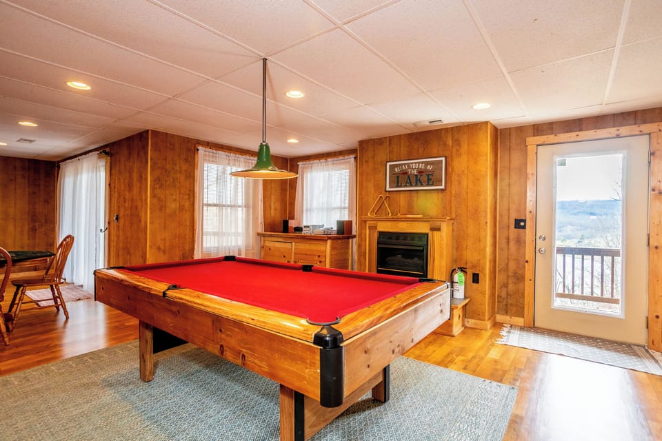Enjoy a game night or relax by the cozy fireplace in this charming game room with access to scenic views and fresh air.