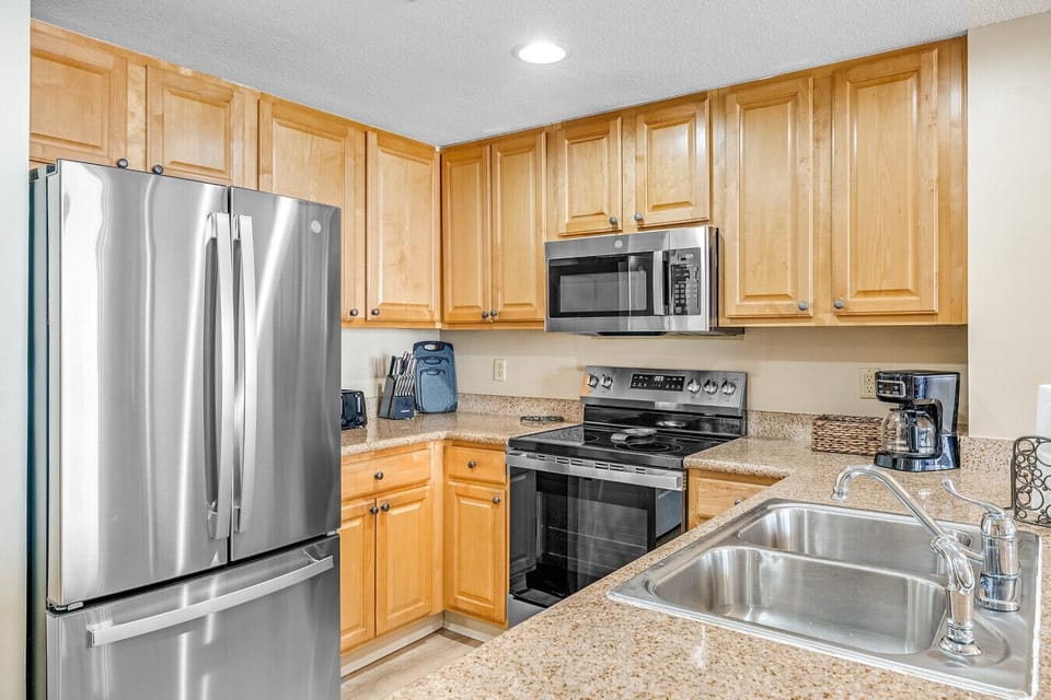 prepare delicious meals in this fully equipped kitchen, featuring stainless steel appliances, granite countertops, and ample cabinet space for all your cooking essentials