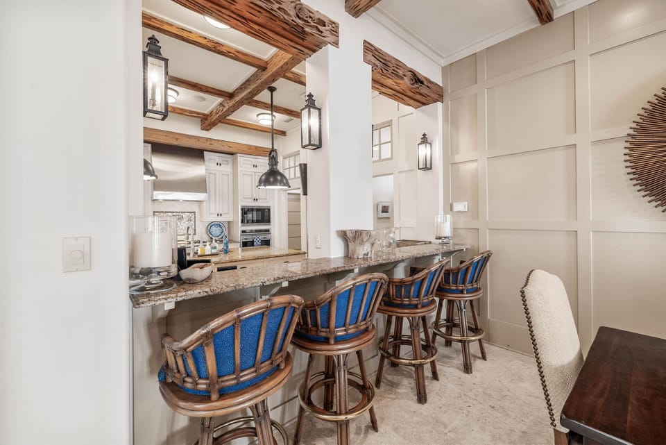 Gather around your spacious kitchen island where rustic wood beams meet elegant granite countertops, creating the perfect spot for morning coffee.