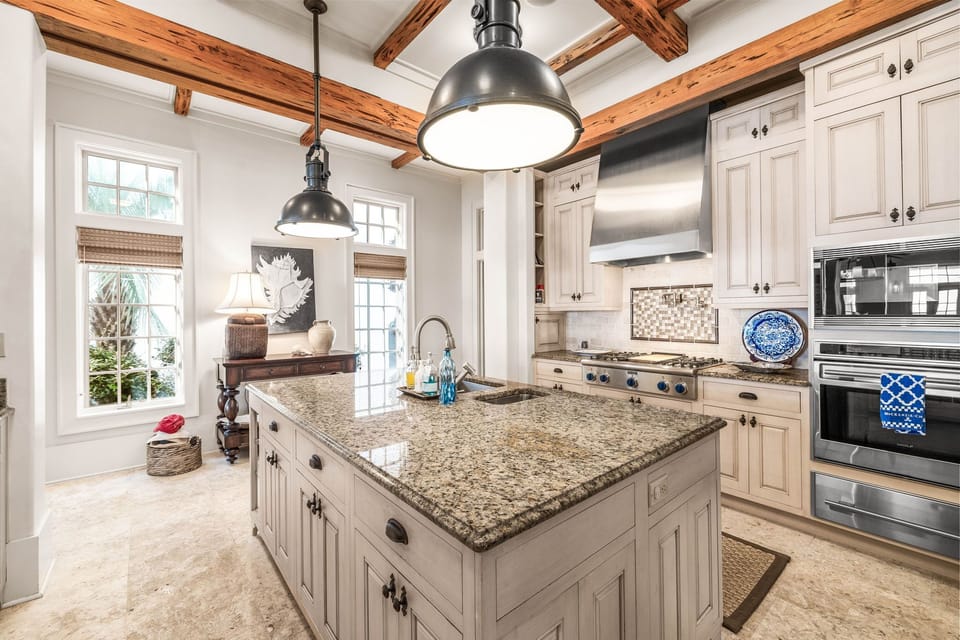 Cook memorable meals in this beautifully appointed kitchen featuring granite countertops and rustic exposed beams overhead.