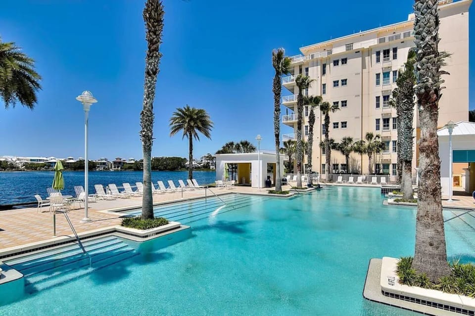 Stunning waterfront pool with crystal-clear waters, swaying palms, and sunbeds awaits your arrival. The scenic lagoon backdrop creates a peaceful retreat for relaxation and enjoyment.