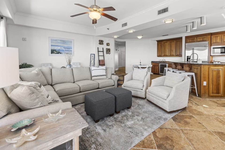 Sink into plush gray seating while your open kitchen beckons with warm wood cabinets and modern appliances for effortless entertaining.