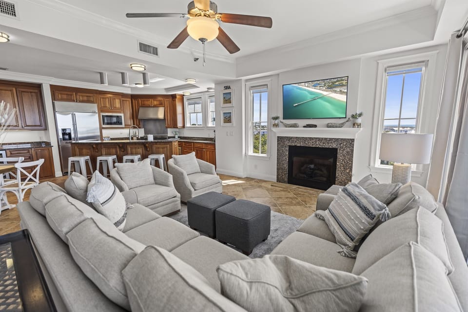 Relax in your spacious living room with plush seating, cozy fireplace, and stunning ocean views through floor-to-ceiling windows.