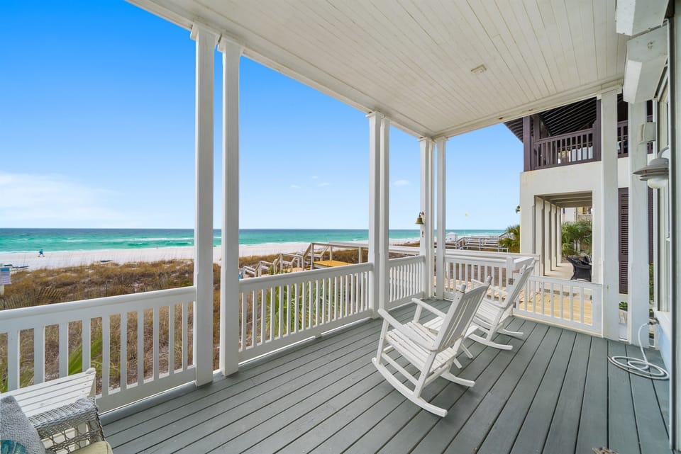 Sway in your rocking chair while turquoise waves dance before you on this covered porch—your perfect perch for morning coffee and endless ocean views.