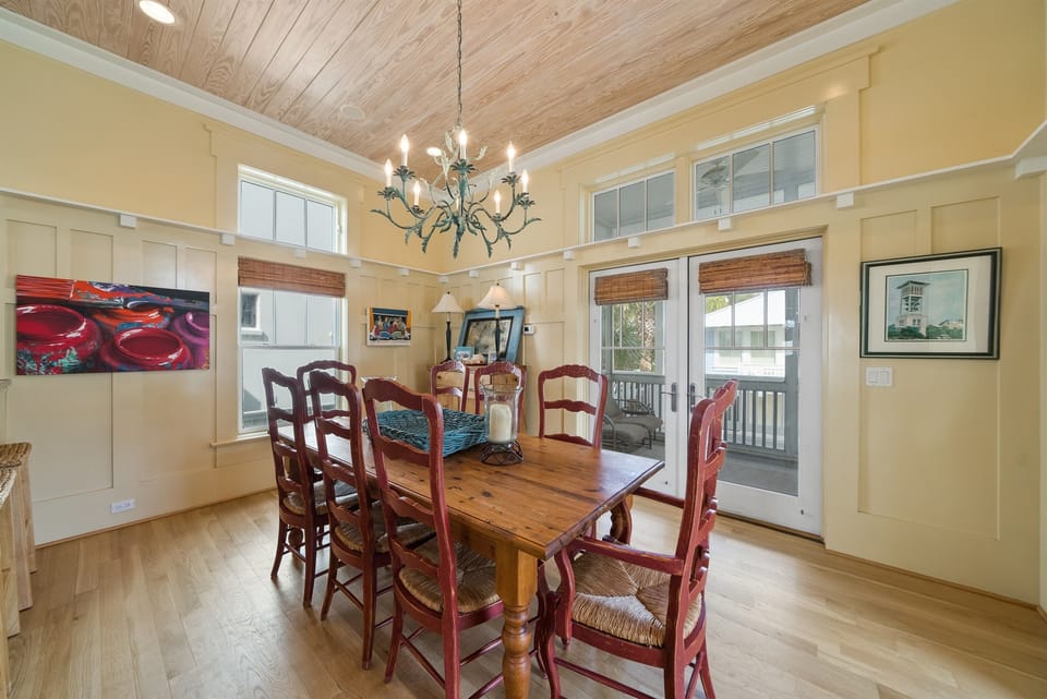 Gather around your rustic dining table beneath soaring wood-beamed ceilings, where warm conversations flow as naturally as sunlight through cottage windows.