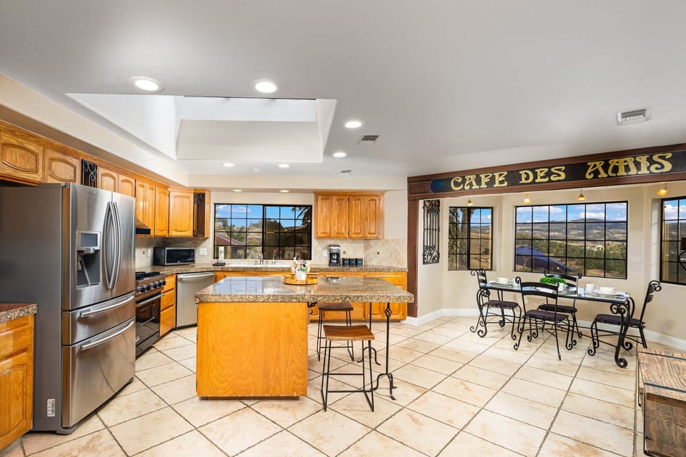Large kitchen with modern stainless steel appliances and gas burners.