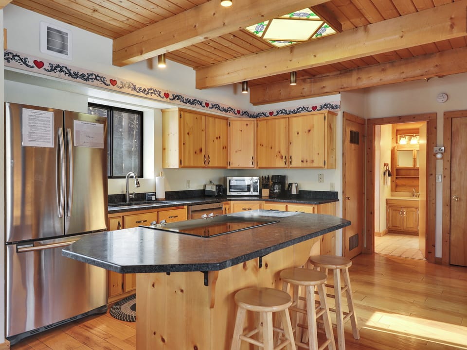 Charming rustic kitchen with a skylight, wooden cabinetry, a functional center island, and counter seating for three.