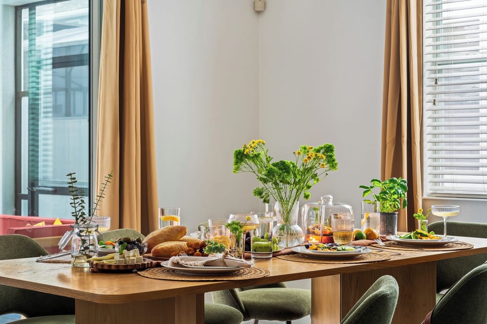  A beautifully set dining table with fresh greenery and warm lighting.