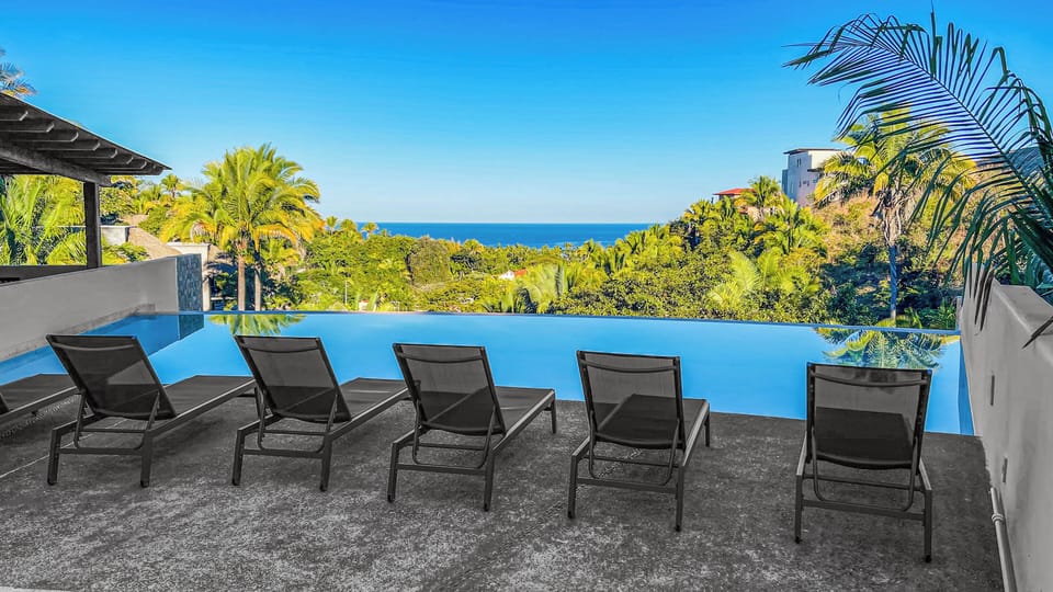 Relax by the pool, with comfortable chairs overlooking the serene ocean.