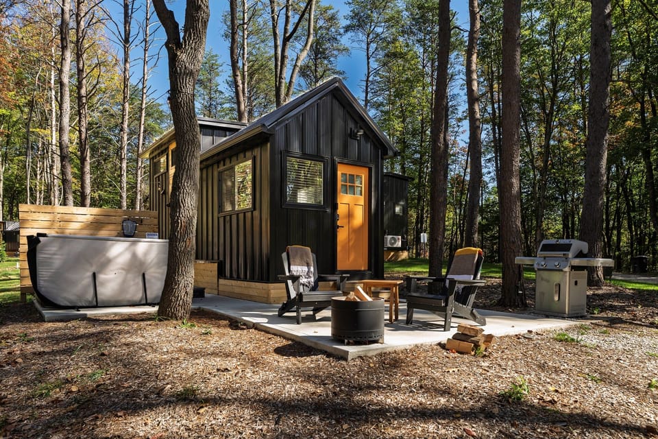 Whitman exterior with hot tub — personal hot tub on the deck, Adirondack seating, wooded setting
