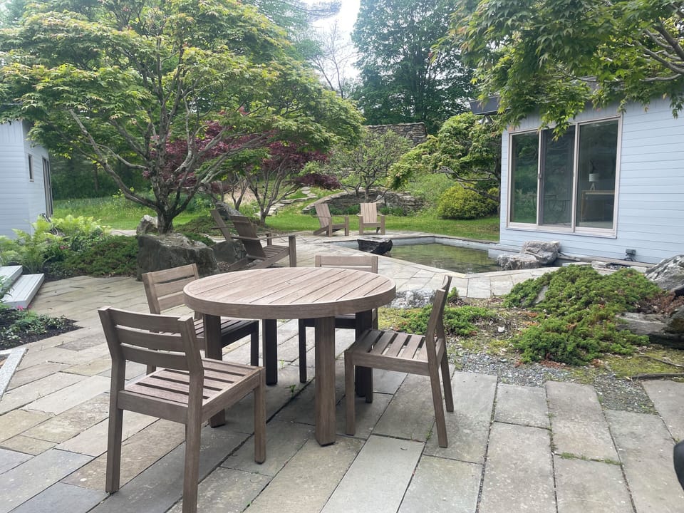 Courtyard with water feature, dining table and adirondack chairs