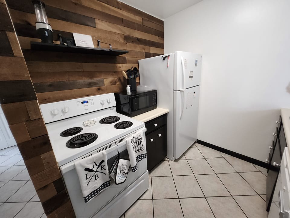 Full kitchen with stove top, oven, microwave, and full-size fridge 