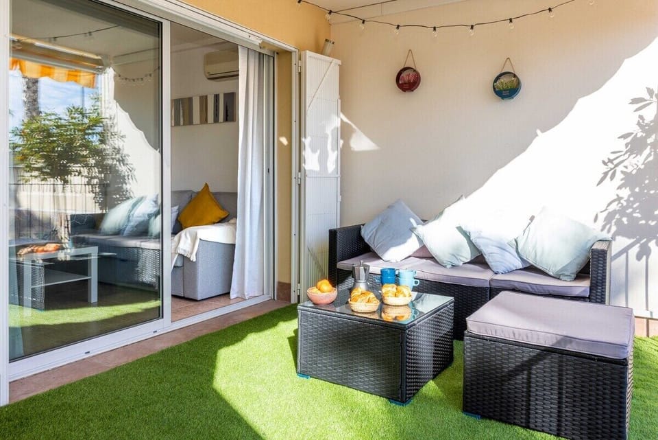 Cozy terrace with comfortable seating and lush artificial grass, perfect for relaxing outdoors.