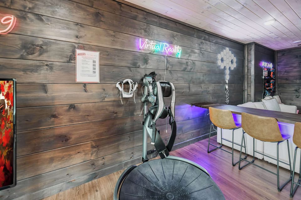 Modern game room featuring virtual reality equipment and a bar seating area.