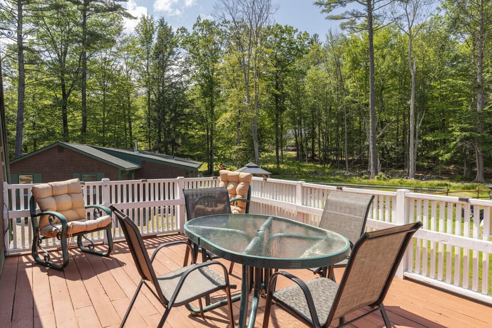 Spacious deck with outdoor seating surrounded by peaceful nature.