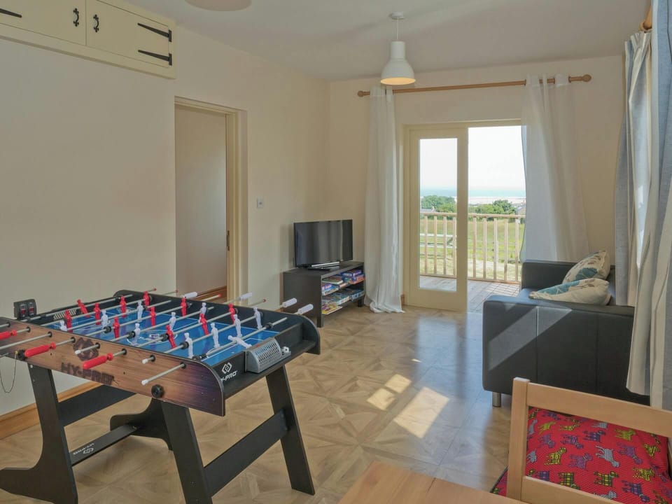 Table football, TV, sofa and patio doors