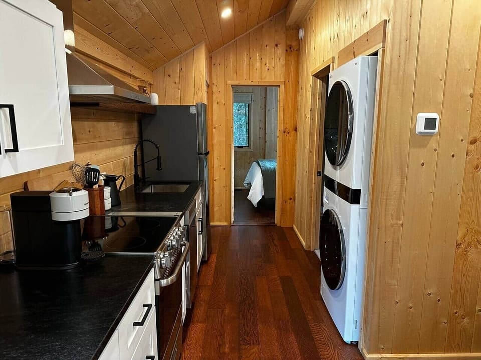 Modern kitchen with full appliances, cookware, and in-unit washer & dryer for extended stays.