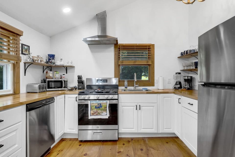 Fully equipped kitchen with stainless steel appliances and modern farmhouse design.