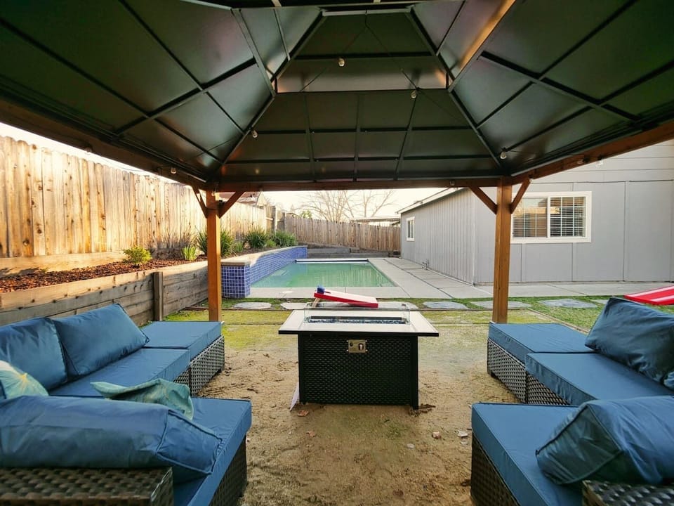 Relax under the gazebo with plush seating, a cozy fire pit, and a stunning view of the pool. Ideal for unwinding after a day of funn
