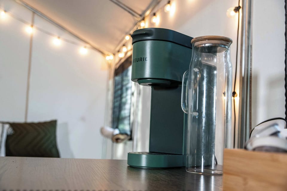 Equipped with a Keurig coffee maker, coffee pods, and cups.