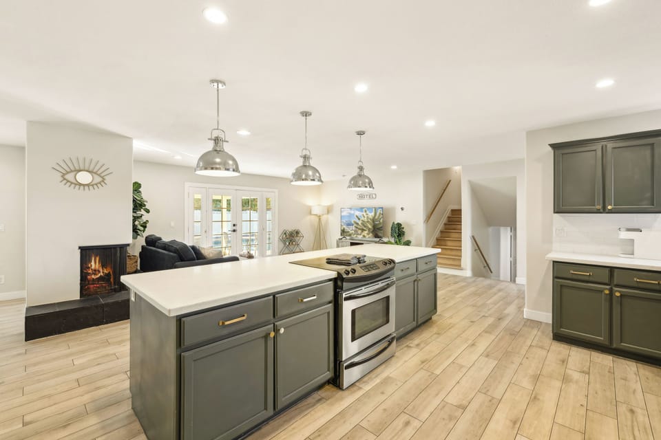 A stunning open-concept kitchen featuring a sleek island with stove top.