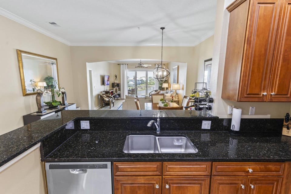 Kitchen sink and counter with views of open-concept dining and living room, blending functionality with expansive indoor space.