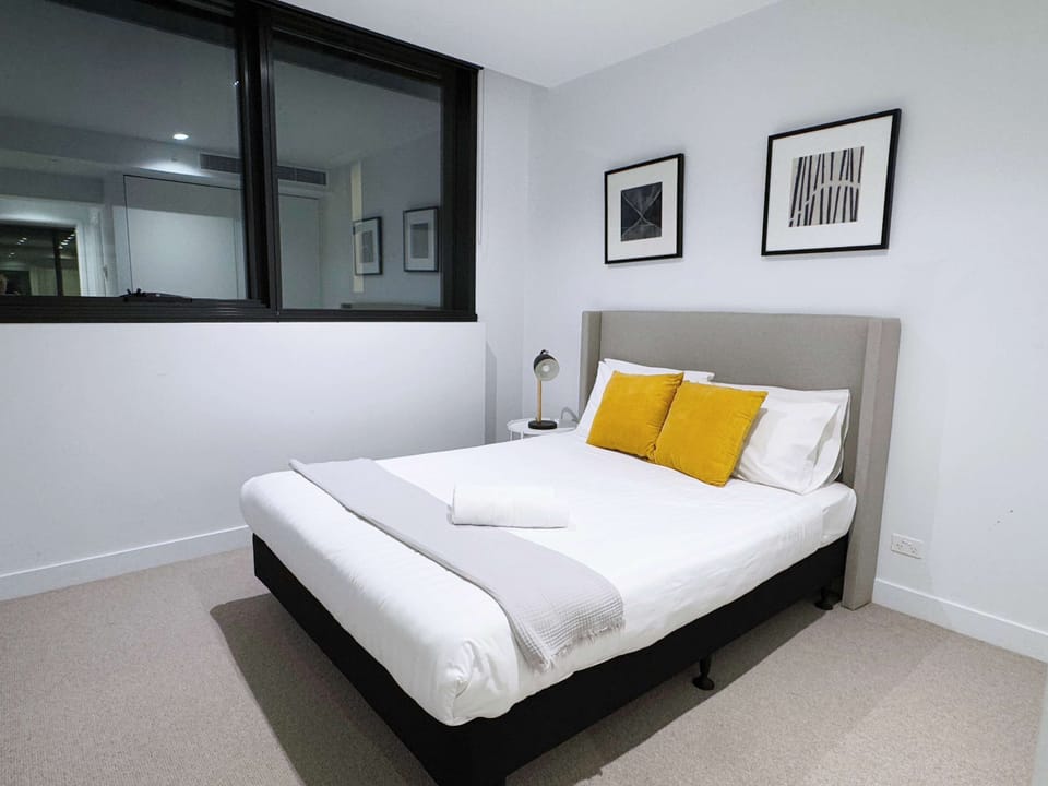 The master bedroom with a queen sized bed & plush pillows.