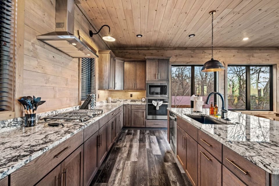 The fully equipped kitchen at Wellevate Lodge features modern appliances, granite countertops, and ample space for preparing meals. Enjoy cooking with a view, surrounded by rustic charm and elegant finishes in this inviting mountain retreat.
