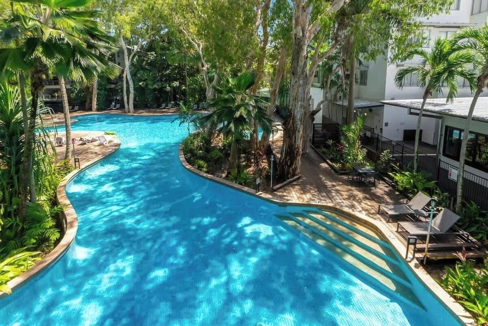Float in the sparkling lagoon-style pool or soak up the sun on the inviting loungers, all while surrounded by lush tropical greenery for the ultimate resort escape.